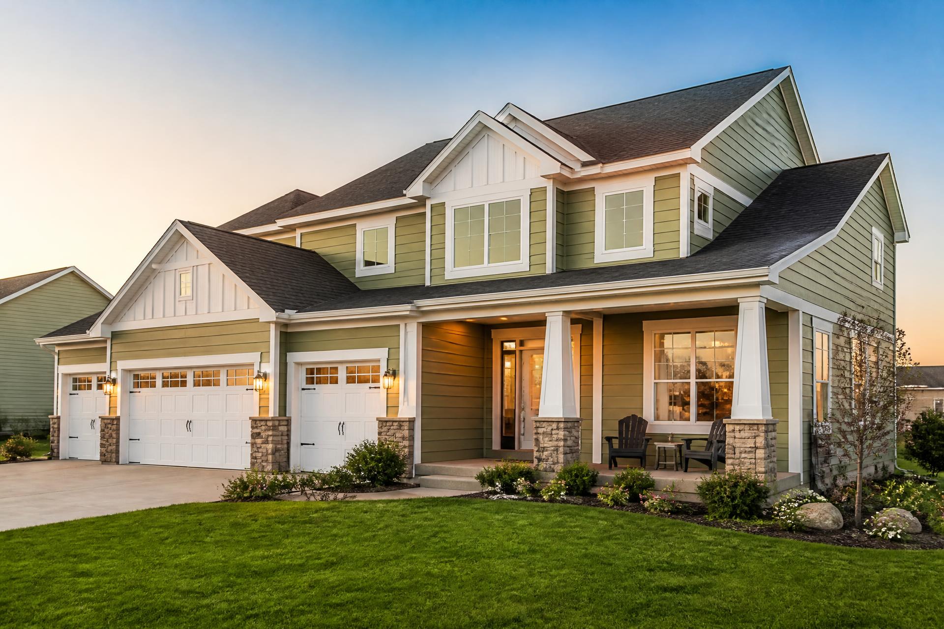 Two-story Minnesota home with a new architectural shingle roof and engineered wood siding at golden hour